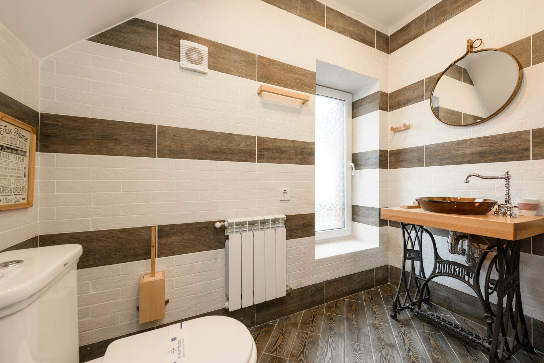 Mała łazienka z drewnianą szafką pod umywalką i nowoczesną armaturą