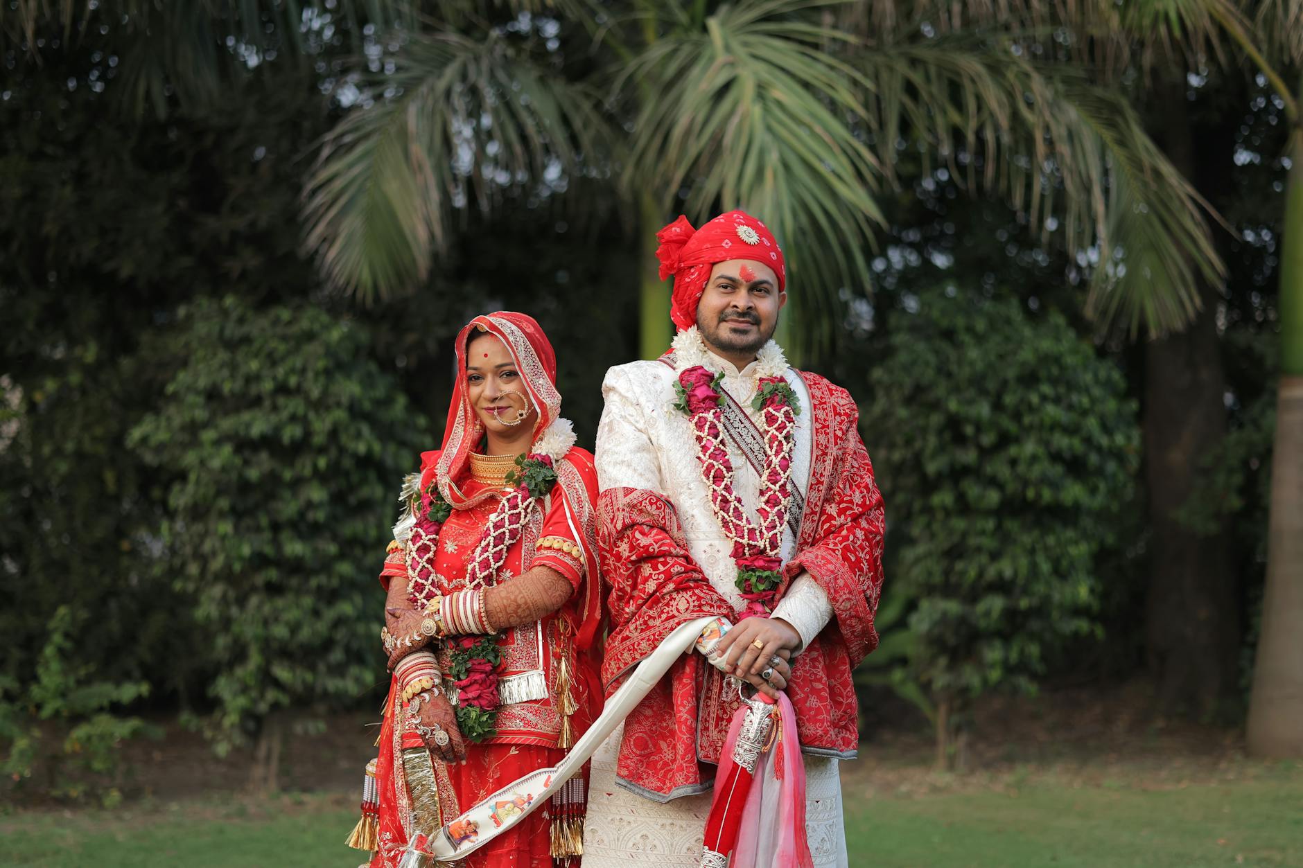 Para młoda w indyjskich strojach ślubnych pozuje w plenerze