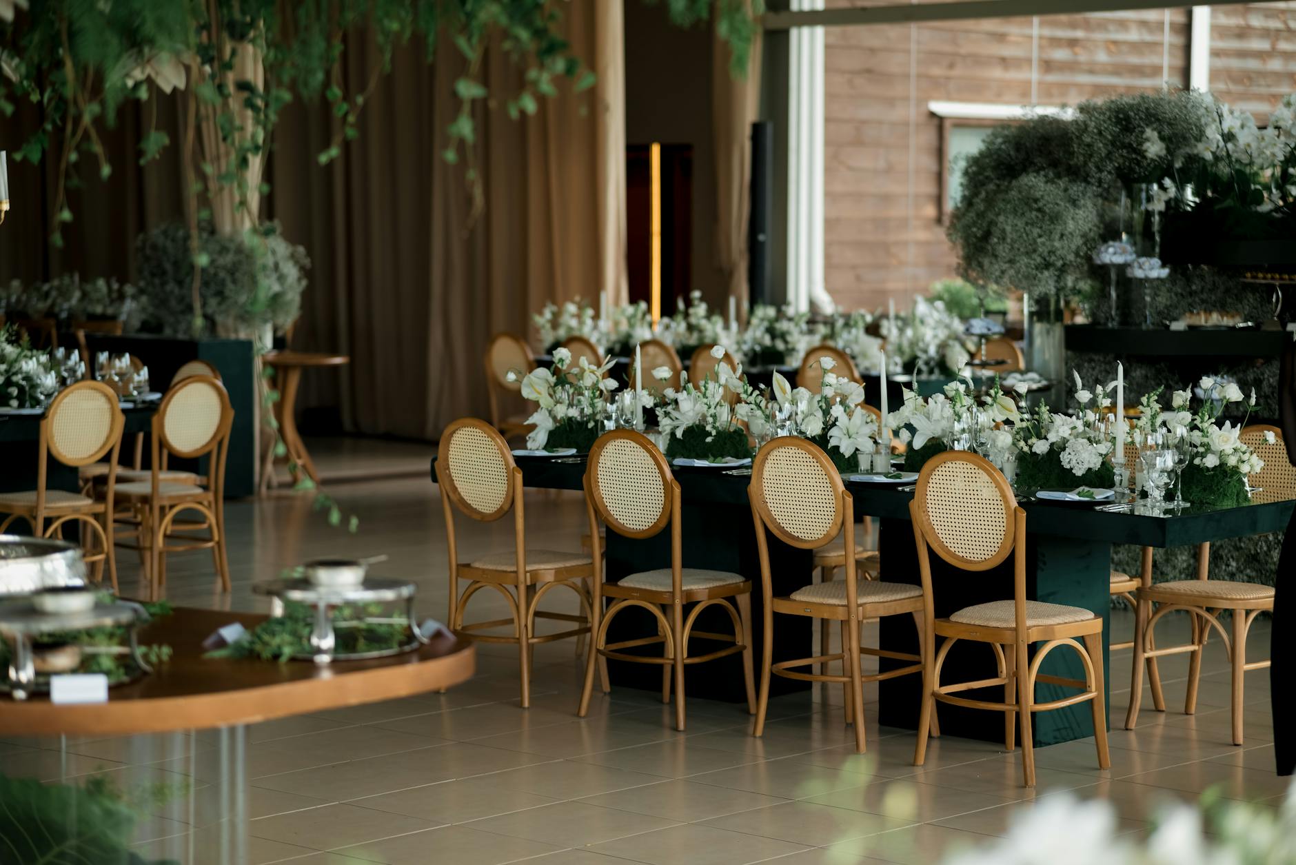 Elegancka sala weselna z kwiatowymi dekoracjami i stołami dla gości