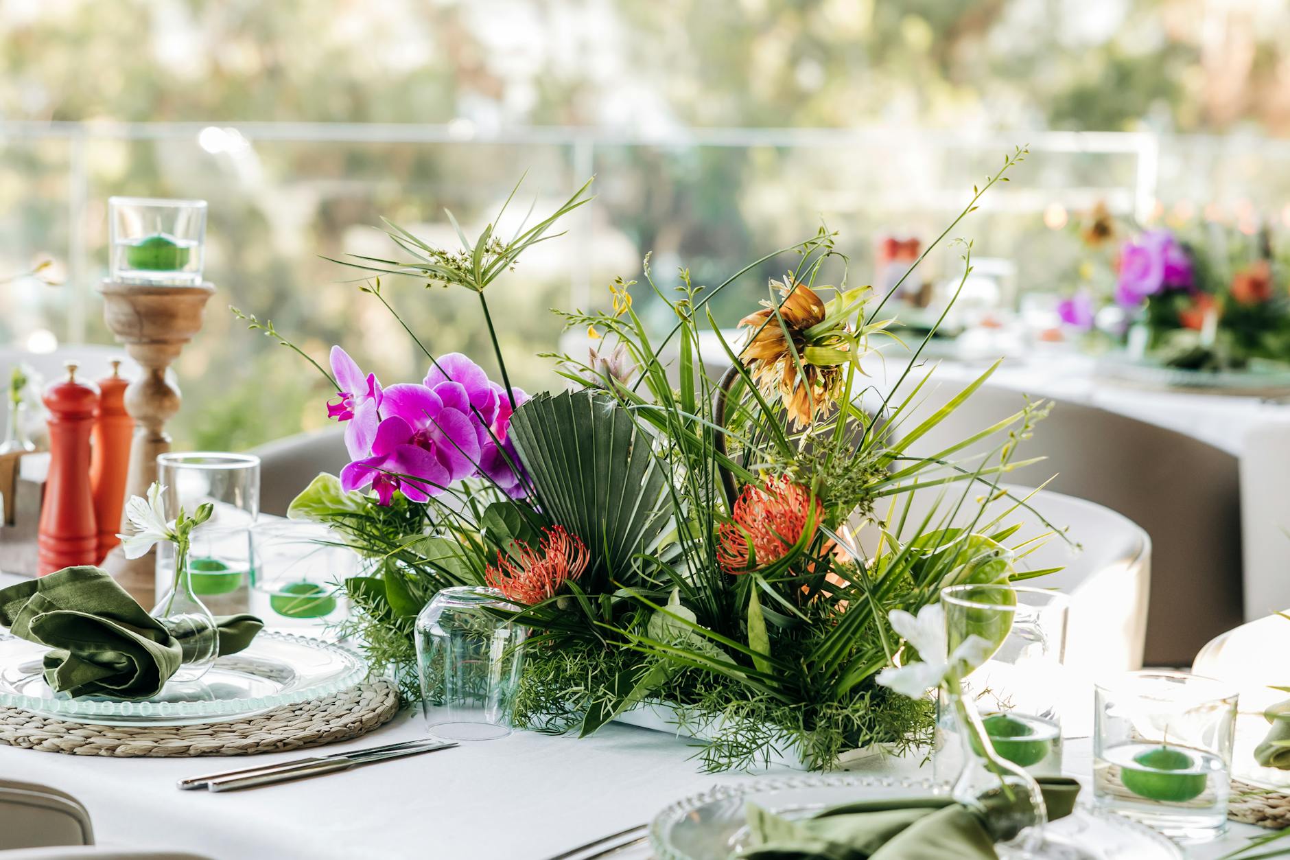 Kwiatowa kompozycja z orchidei na plenerowym stole wesela zero waste