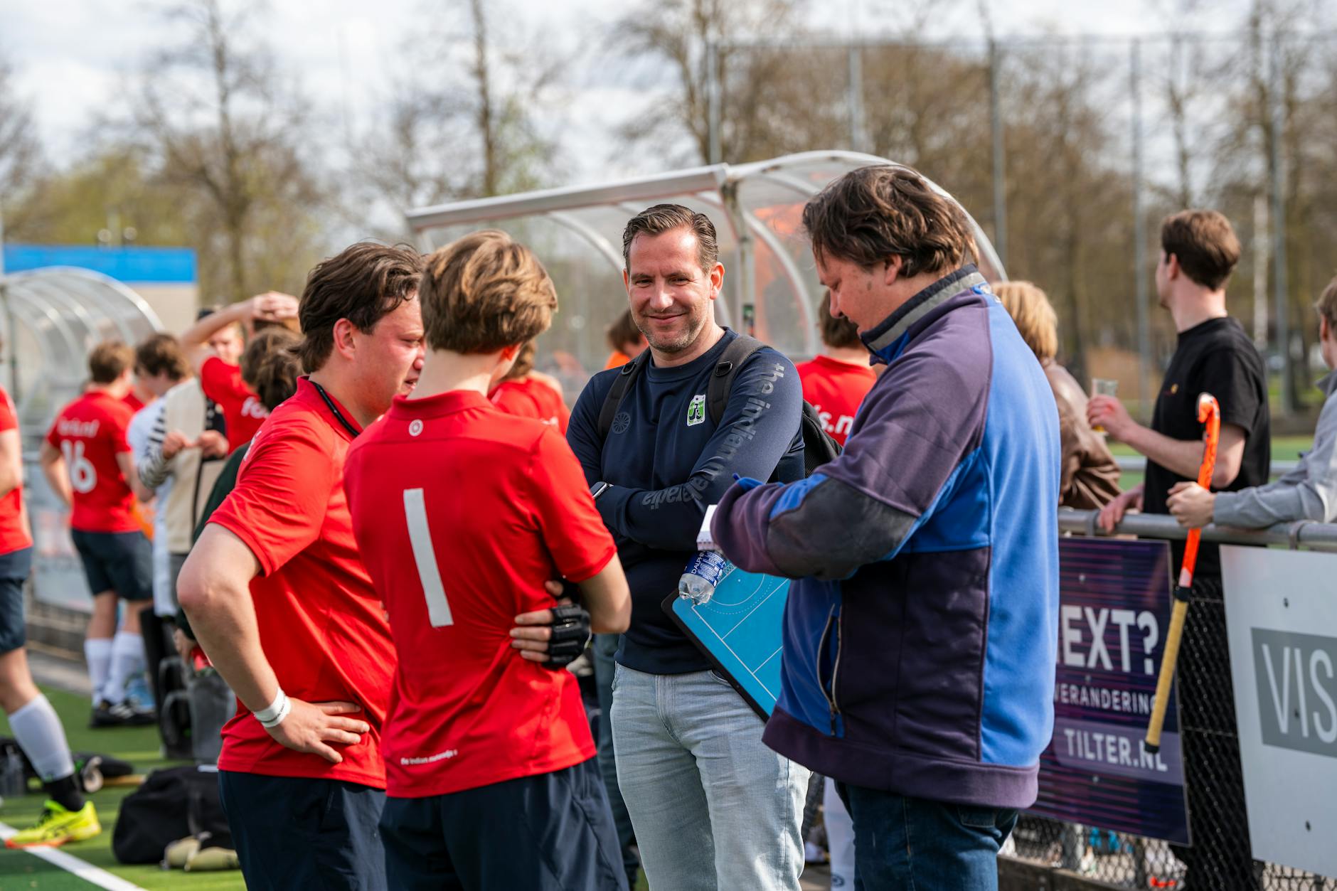 Trenerzy i hokeiści na boisku omawiają wspólną strategię zespołu