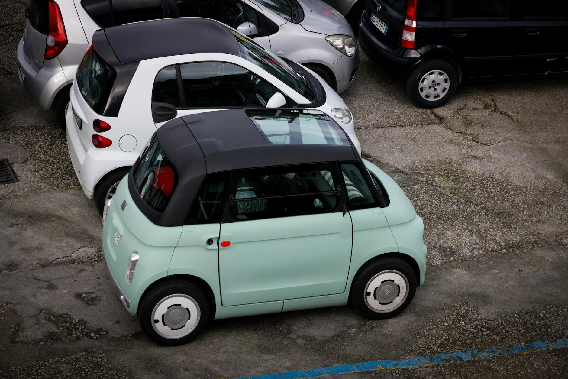 Szereg mikrosamochodów zaparkowanych blisko siebie na miejskim parkingu