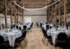 Ile kosztuje talerzyk na wesele w Lubuskiem i co zwykle obejmuje cena? Rustykalna sala weselna z elegancko nakrytymi okrągłymi stołami